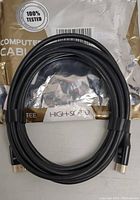 High-speed HDMI cable coiled and secured with a clip, showing connectors and package.