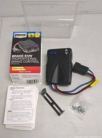 Proportional brake control unit laid out with mounting bracket, screws, instruction manual, and packaging box showing product and usage detail.