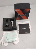 Two Sealight Xenower LED bulbs secured in protective foam insert with accessories including gloves, cleaning cloths and manuals.