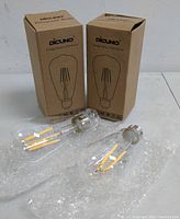 Two vintage style Edison LED bulbs placed on surface with original Dicluno branded boxes behind them