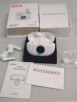 Image showing A10Pro True Wireless Earphones with charging case, user manual, accessories box, and additional accessories in plastic bag on a flat surface.