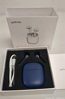 Blue Yobola T19 wireless earbuds in charging case, USB charging cable, user manual inside original white branded box showing front and interior with foam insert.