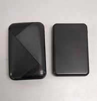 Top view of two black power banks showing front surfaces; larger one with textured design, smaller one smooth with LED indicator lights.