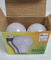 Two white globe-shaped 9W LED bulbs with GU24 base inside retail box showing product details and brightness info.