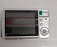 Rear view of the silver digital camera showing large LCD screen and buttons.
