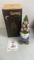 Front view of gnome solar statue showing colorful design, flowers on hat, and original box.