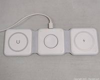 Three connected white wireless charging pads laid flat, showing magnetic ring on center pad and charging symbols on outer pads.