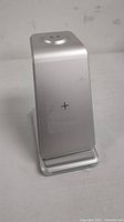 Silver 3-in-1 wireless charging station showing the vertical charging pad with plus sign on front panel.