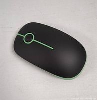 Top view of black wireless computer mouse with green trim lines for style and buttons.