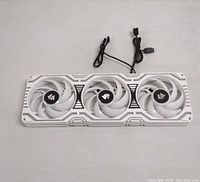 Photo of the Asiahorse Matrix PC cooling fan with three white blades fans set in white and silver patterned frame, showing overall design and fans.