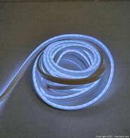 Coiled Monster LED strip light illuminated with bright white light, showing flexible nature of strip.