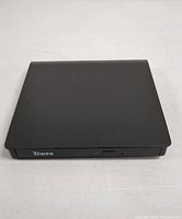 Closed top view of the black Ziuveo branded portable external optical disc drive and HDD device showing a smooth matte finish and front panel with logo and button.