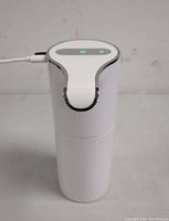 White Yikhom sensor soap dispenser powered via USB cable with green illuminated sensor and power indicators on top panel.
