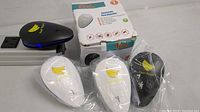 Set of 3 pest repellers and 1 black unit on top of a strip outlet, showing front design and logos.