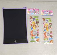 Front side of the purple-framed erasable drawing tablet with black wipeable surface and two identical sticker packs featuring animal designs.