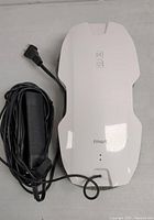 Top view of the white FMART window cleaning robot showing power cord and two control buttons.