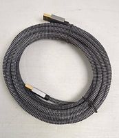 Coiled black and gray braided nylon USB cable with male USB connectors on both ends against a white background.