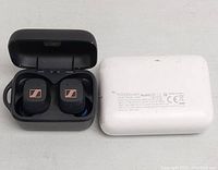 Black Sennheiser CX Plus true wireless earbuds inside open charging case with copper logo visible, next to white 10,000mAh power bank