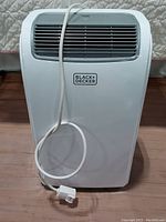 Front view showing the Black & Decker logo and air vent with power cord wrapped around the unit.