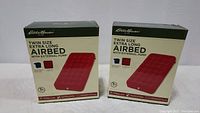 Two unopened boxes of Eddie Bauer Twin XL airbeds displaying brand and product sizes.