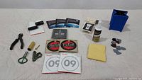 Full lot of assorted guitar care and stringing items arranged on a surface including strings, picks, tools, and polish.
