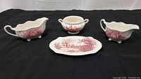 Front view of the five pieces: two gravy boats, creamer, sugar bowl, and serving platter, with Johnson Brothers red transferware pattern.