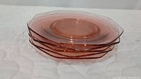 Stacked view of six pink octagonal luncheon/salad plates showing the translucent pink color and shape detail.