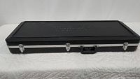 Closed black Schecter hard case on table