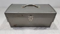 Gray metal toolbox closed, showing the latch lock and handle