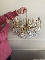 Front view showing overall chandelier held by hand