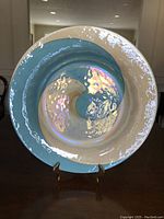Front view of the large iridescent glass bowl showing the blue and cream swirl design and textured surface.