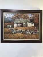 Overall view of the painting framed, showing rustic house in autumn landscape with stone wall and textured oil paint.