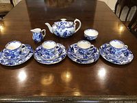 Full set: 1 teapot, 1 creamer, 1 sugar bowl, 4 tea cups with saucers displayed