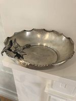 Front-side view of scalloped-edge bowl showing bird-on-branch ornament