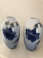 Pair of Royal Copenhagen peony trumpet flower vases, front and side views showing floral decoration and shape.