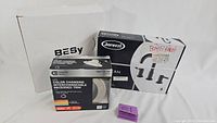 Full view of the three boxed items including BESy shower head, Jacuzzi bath faucet set, and Commercial Electric LED trim