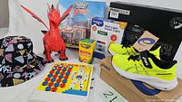 Full group image showing shoes, hat, dinosaur toy, crayons, Hangman game and Red Light Green Light game box