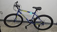 Full side view of the blue Ozone 500 mountain bike showing frame, tires, saddle, and handlebar setup.