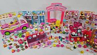 Wide shot showing the full playset with all items including food truck, store shelves labeled by food category, and numerous small characters and accessories arranged around.