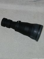 Side view of ATN 8x magnifier optic lens showing the eyepiece and adjustment knob.