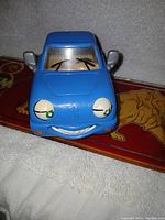 Front view of the blue Chevron toy car showing smiling face with eyes on headlights and windshield wiper eyebrows.