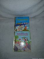 Stack of three vintage Little Golden Books showing titles with colorful illustrated covers titled The Three Bears in Town, Mother Goose, and Favorite Nursery Tales.