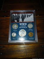 Front view of WWII coin series case with five coins mounted on blue felt, background photo and coin names.