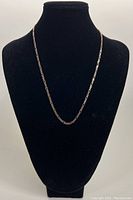 Full-length view of chain displayed on black bust to show overall appearance, length and drape