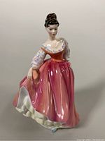 Front view of Royal Doulton 'Fair Lady' porcelain figurine in peach-pink dress.