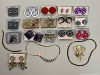 All jewelry items arranged neatly including earrings, necklaces, bracelets, and brooches in original display cards or loose.