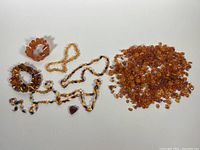 Full lot view with multiple amber bracelets, necklaces, and beads shown, highlighting color range and bead types.