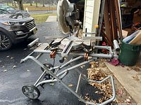 Photo of the Chicago Electric 12-inch sliding compound miter saw mounted on the Ridgid wheeled base, showing the miter saw from an angle with support arms extended.