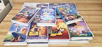 Photo showing a selection of Disney VHS tapes with covers including Pinocchio, Cinderella, Toy Story, Lady and the Tramp, Fox and the Hound, and Alice in Wonderland.