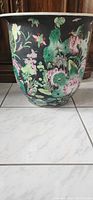 Large porcelain floral vase with colorful hand-painted flowers, foliage and butterflies on a black background.
